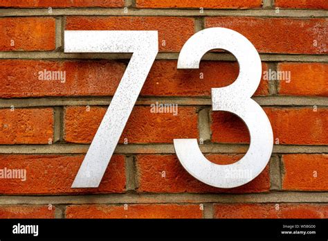 House number 73 on a red brick wall Stock Photo - Alamy