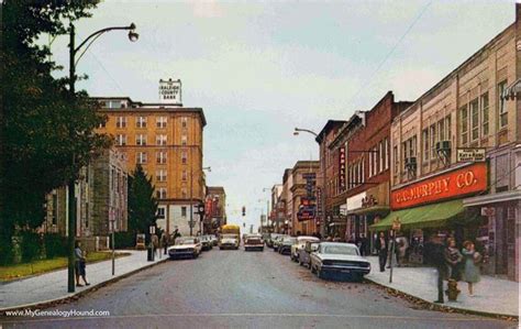 an old photo of a street with cars parked on the side