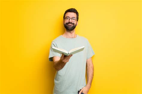 Premium Photo | Man with beard and green shirt holding a book and ...