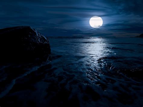 Premium Photo | Night time over the ocean with rock and full moon