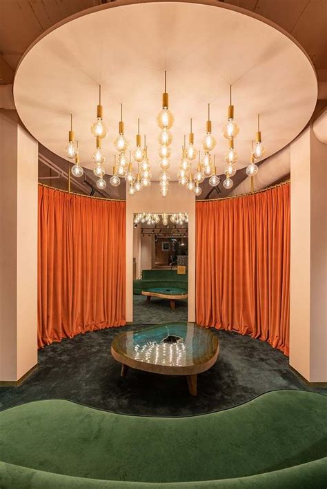 a living room filled with furniture and orange drapes hanging from the ceiling over a round ...