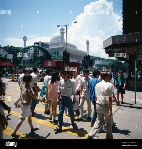 Menschen auf einer Straßenkreuzung vor der Kowloon Moschee, Hongkong 1980er Jahre. People ...