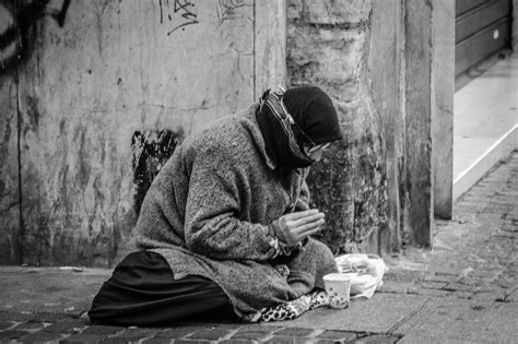 Grayscale Photography of Man Praying on Sidewalk With Food in Front · Free Stock Photo