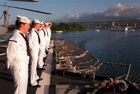 Crew members man the rails aboard the guided missile cruiser USS CHOSIN ...