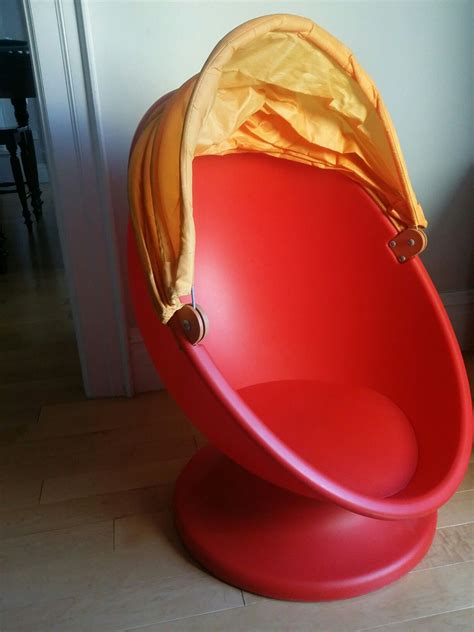 a red chair with a yellow cover sitting on top of it's back legs