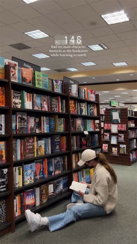 a woman sitting on the floor in front of a bookshelf filled with books