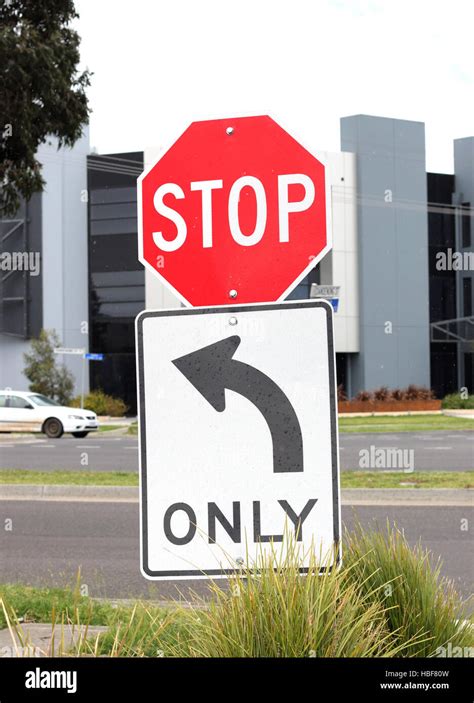 Stop sign with turn left arrow only Stock Photo - Alamy