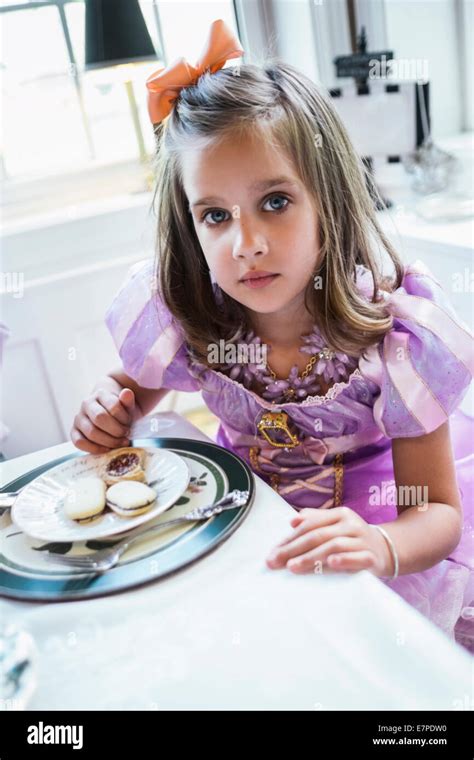 Girl (4-5) eating cookies at dining table Stock Photo - Alamy