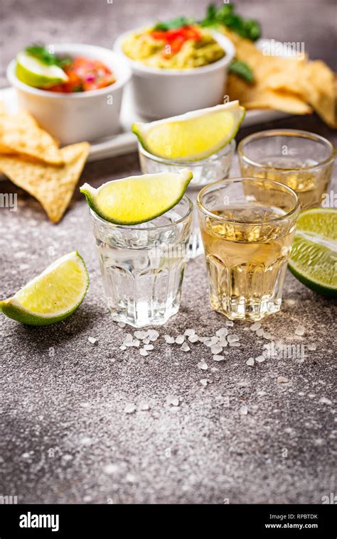 Shots of silver and gold tequila Stock Photo - Alamy