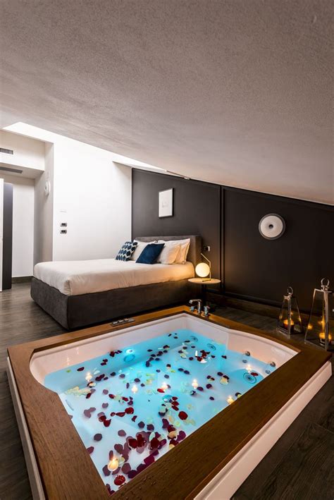 a room that has a large hot tub in the middle of it and candles on the floor