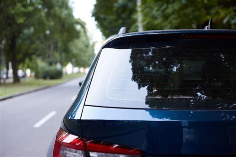 Premium Photo | Back window of blue car parked on the street in summer sunny day, rear view ...