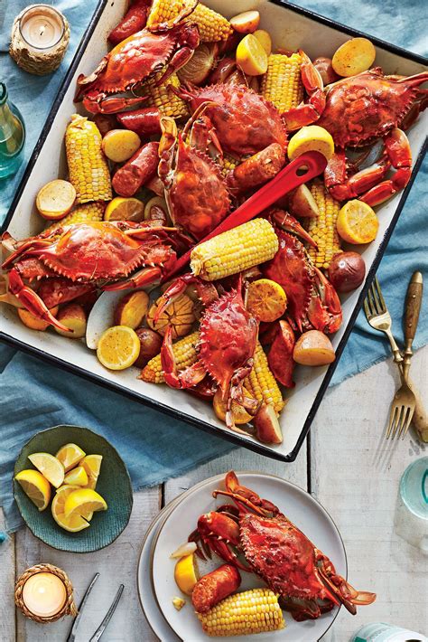 lobsters, corn on the cob and potatoes are laid out on a tray