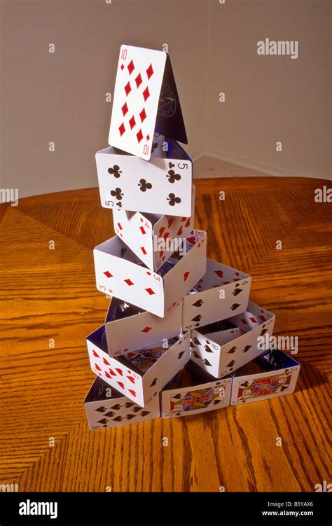 Playing cards stacked into a "house of cards" on table Stock Photo - Alamy