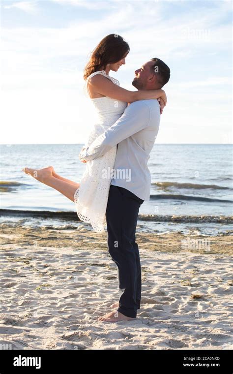 man lifting woman at beach Stock Photo - Alamy