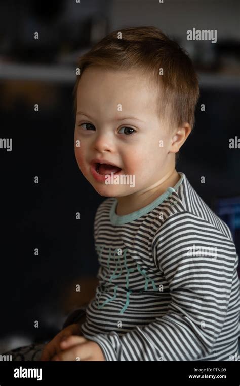 Portrait of cute small boy with Down syndrome in home Stock Photo - Alamy