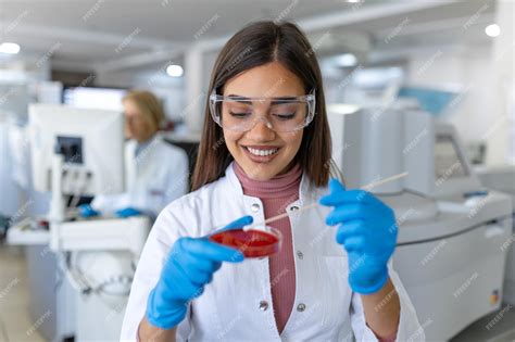 Premium Photo | Petri dish in hand of young scientist near microscope in laboratory bacterial ...