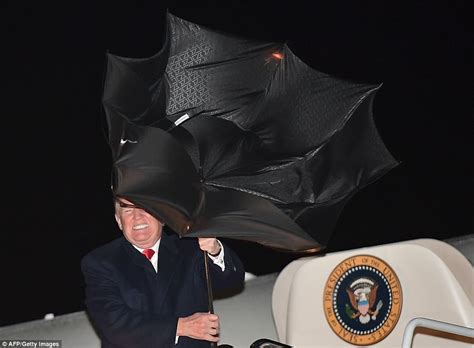 President Trump grapples with his umbrella after rally | Daily Mail Online