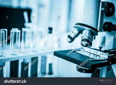 Microscope in microbiology lab with laboratory glassware background for medical research or ...