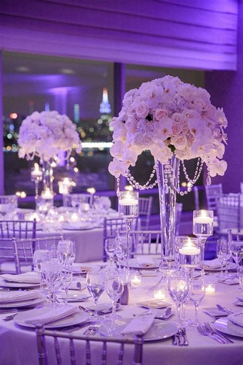 the tables are set with white flowers and candles