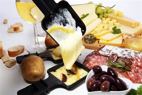 Delicious traditional Swiss melted raclette cheese on diced boiled or ...