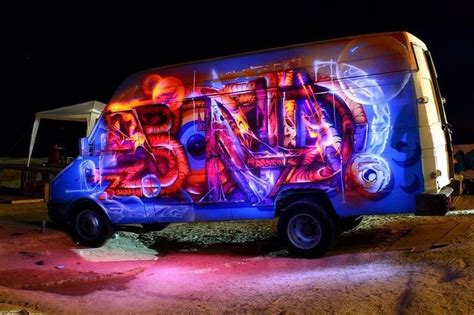 a van covered in graffiti sitting on the side of a road