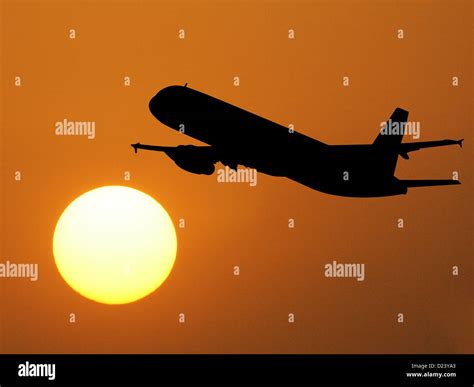 Plane taking off into the sunset Stock Photo - Alamy