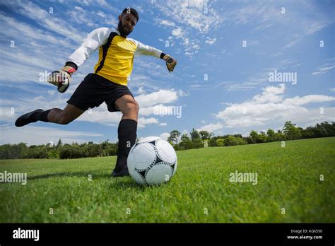 Mixed race man kicking soccer ball hi-res stock photography and images - Alamy