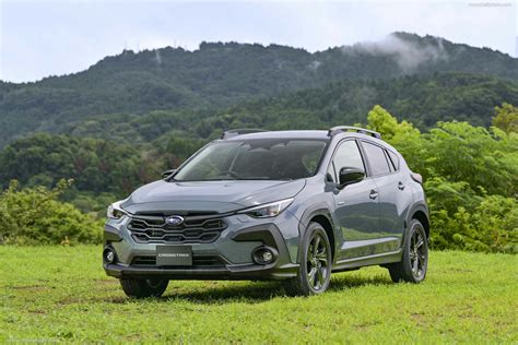 the front end of a gray subarunt parked on top of a lush green field