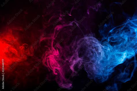 abstract shapes of mixed colors of blue and red smoke at dark ...