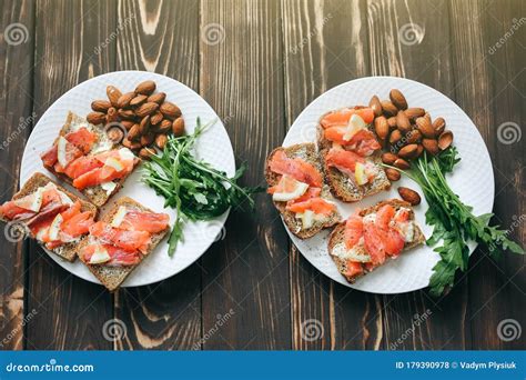 Volkorenbrood Met Zalm Op Witte Plaat. Arugula En Amandelen Met Citroen. Gezonde Sandwiches ...