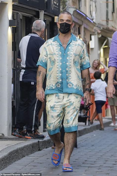 Robbie Williams turns heads in cream and blue floral shirt and shorts while out for dinner ...