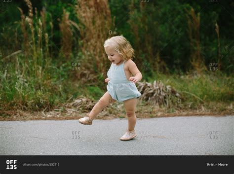 Happy toddler walking alone on a path stock photo - OFFSET