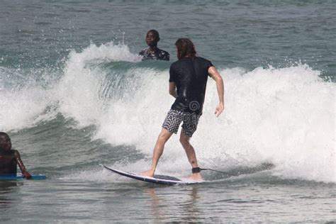 A Tourist is Enjoy Surfing in Lagos Beach while Two Admirers Watch Editorial Photo - Image of ...