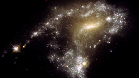 Hubble Space Telescope tells a starry 'tail' of 12 mingling galaxies