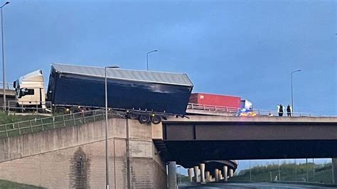 M1 crash leaves lorry hanging off bridge - BBC News