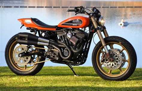 an orange motorcycle parked on top of a lush green field next to a body ...