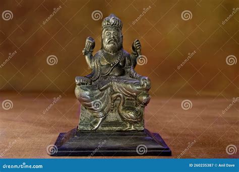 10 23 2014 Vintage Metal Vishwakarma Statue on a Wooden Platform on Coloured Background Kalyan ...