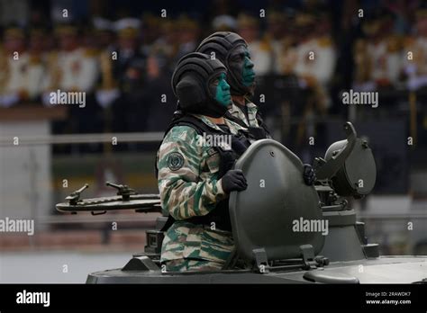 Soldiers ride atop an armored vehicle during an Independence Day ...