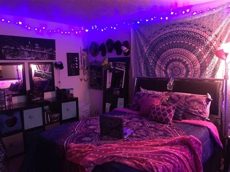a bed room with a neatly made bed and lots of purple lights on the ceiling