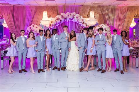 a group of people standing next to each other in front of a table with ...