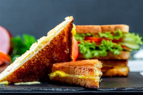 Appetizing sandwich with lettuce, tomatoes, cheese and ham on the man's hand - Creative Commons ...