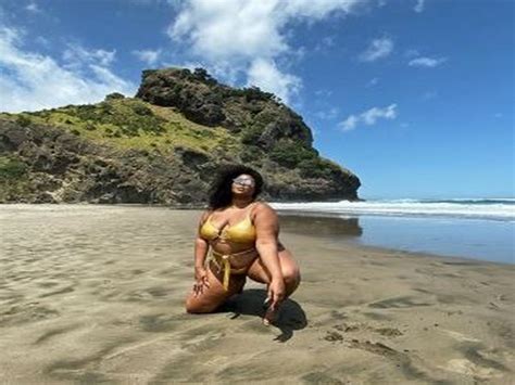 Lizzo flaunts her gold swimsuit in beachside photoshoot