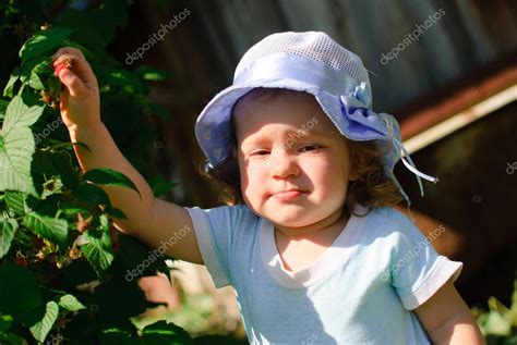 The child eats berries in a garden — Stock Photo © pirozhkov #12926706