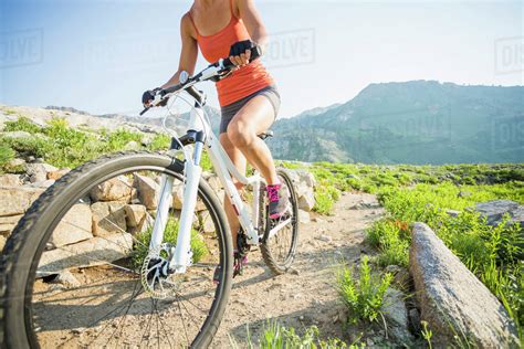 Caucasian woman riding mountain bike on rocky trail - Stock Photo ...