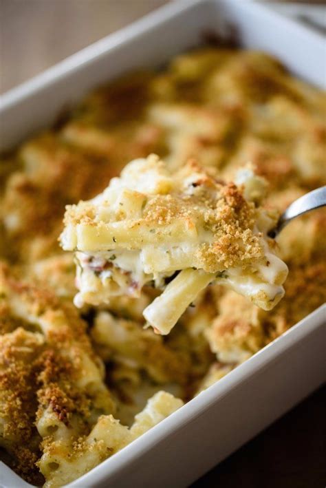 a casserole dish with broccoli and cheese being lifted by a spoon