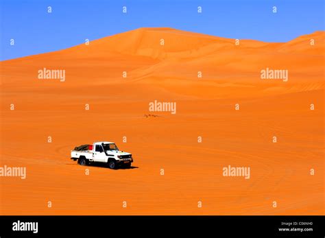 Off-road vehicle in the sand dunes of the Ubari Sand Sea, Sahara, Libya ...