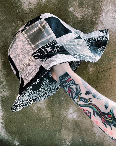 a person's arm with tattoos and a hat on top of it, from above