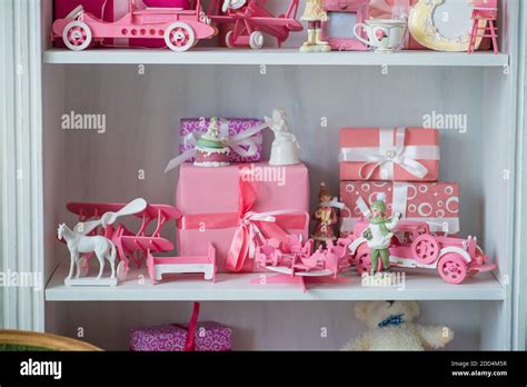 Christmas gifts in box on a shelf, pink car, airplane, wooden horse and gingle bell Stock Photo ...