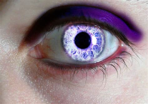 an eye with blue and purple colors on it's iris is seen in this close up photo