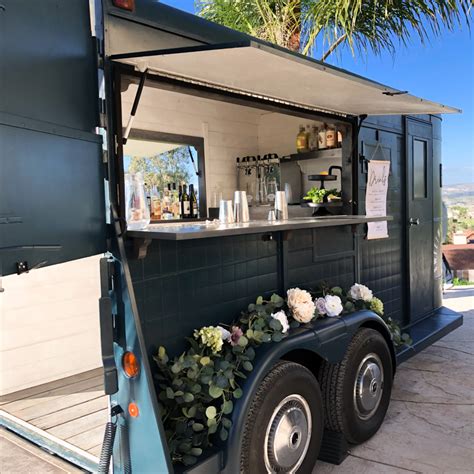 a food truck is parked on the side of the road with plants growing out of it